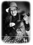 Sylvia Curley holding her father's fiddle