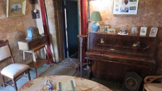 Sitting room at Mugga-Mugga showing a table, chairs and a small upright piano